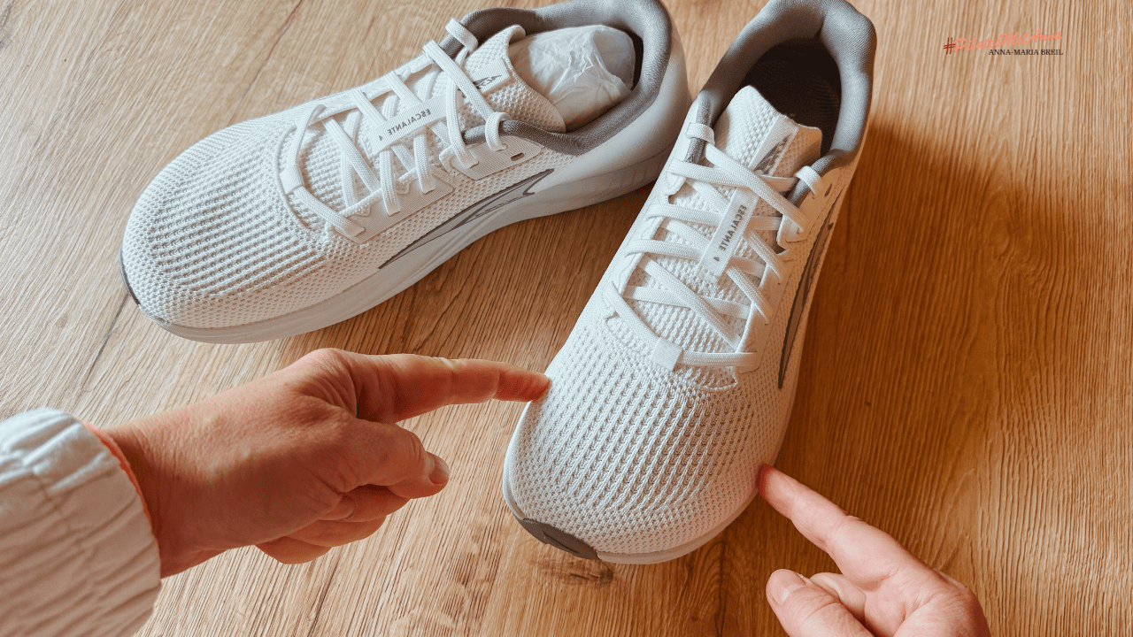 Was sollte ich beim Kauf von Laufschuhen beachten_Zehenbox Auf dem Tisch stehen ein paar Laufschuhe. ich zeige mit den Fingern wo die Zehenbox ist