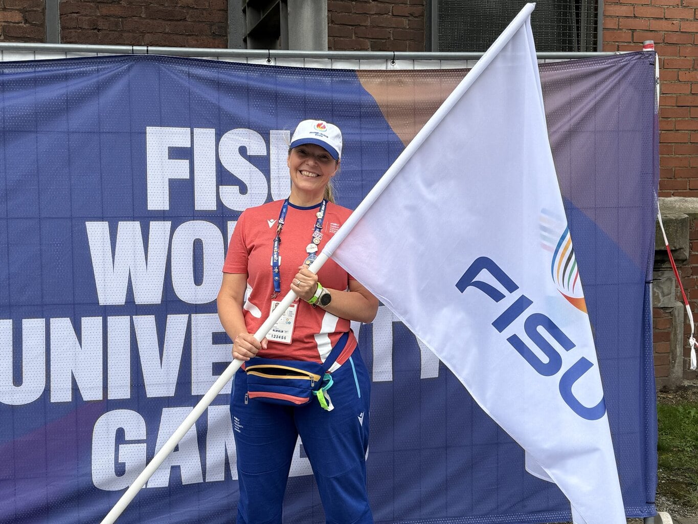 Pilates Anna trägt die FISU Flagge