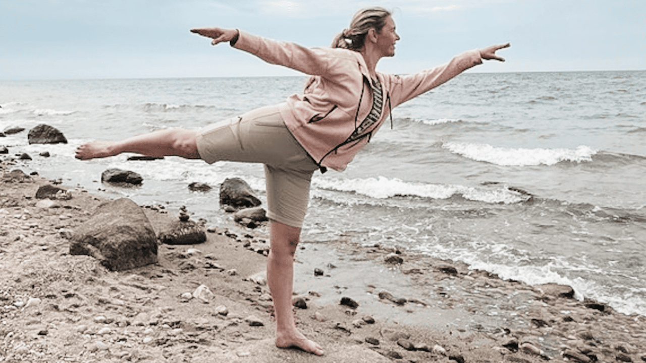 Pilates-Anna in Balance in einer Standwaage am Strand